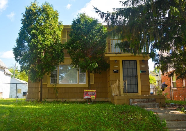 view of front of house featuring a front lawn and fence