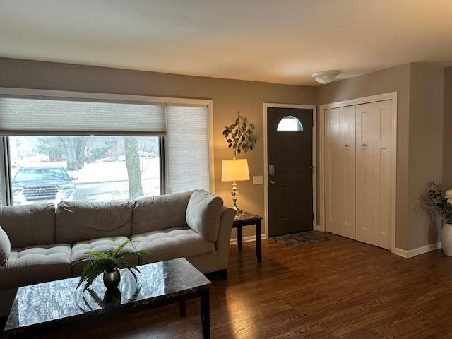 living room featuring dark wood-style flooring and baseboards