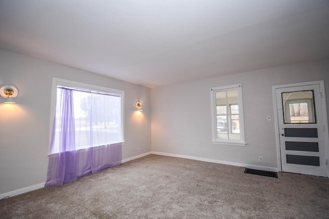 carpeted empty room featuring visible vents and baseboards