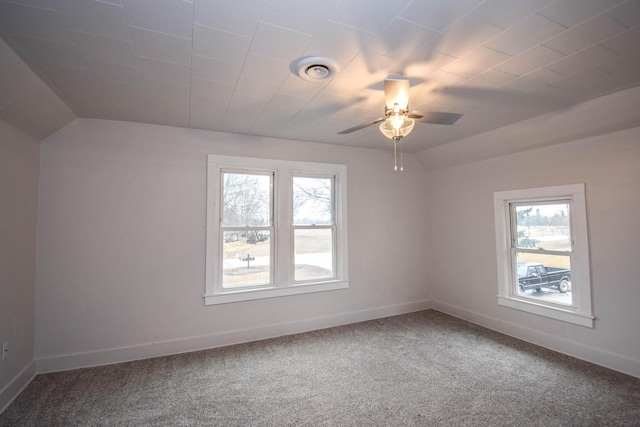 carpeted spare room featuring lofted ceiling, ceiling fan, visible vents, and baseboards