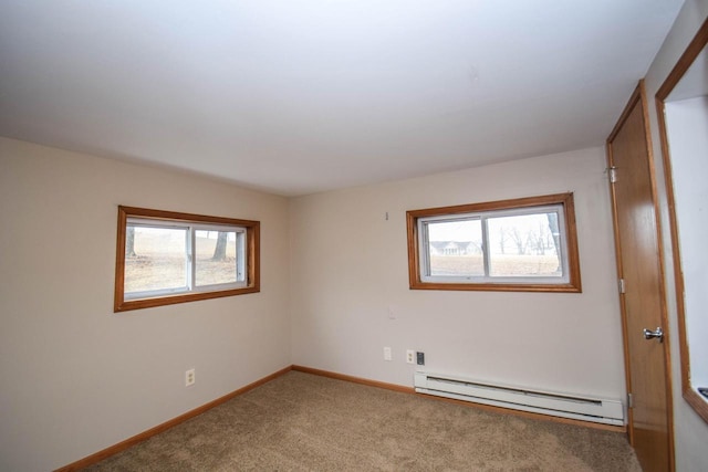 spare room with a baseboard radiator, baseboards, and carpet