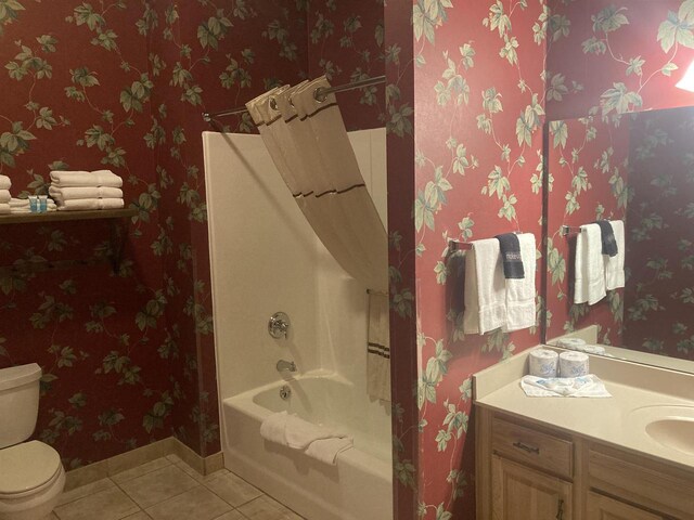 full bath featuring tile patterned flooring, toilet, vanity, baseboards, and shower / bath combo with shower curtain