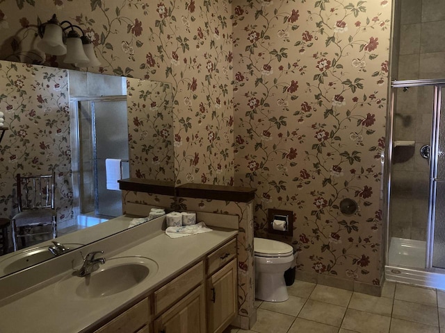 bathroom featuring tile patterned flooring, toilet, vanity, a shower stall, and wallpapered walls