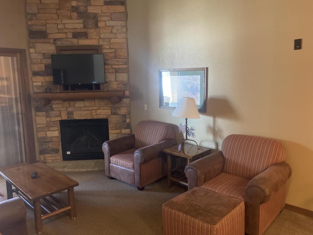 carpeted living area with a stone fireplace