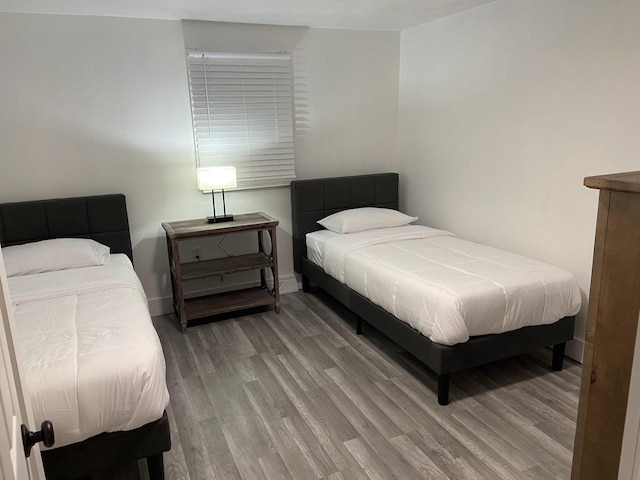 bedroom featuring wood finished floors and baseboards