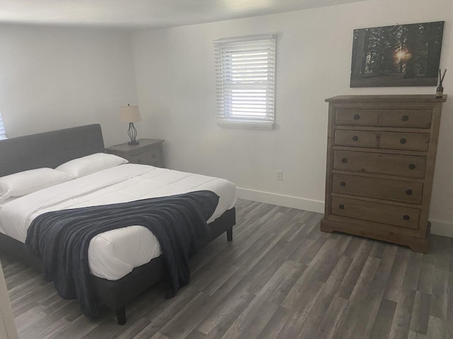 bedroom with dark wood-style flooring and baseboards