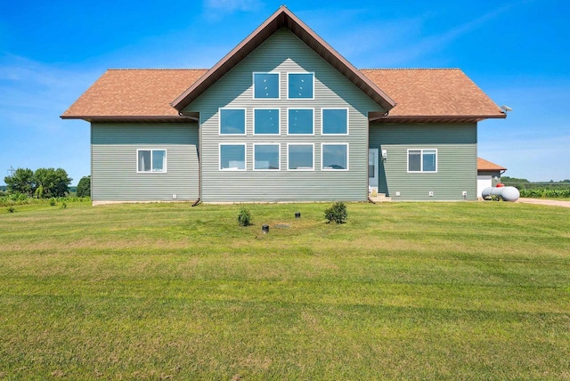 rear view of property with a yard and roof with shingles