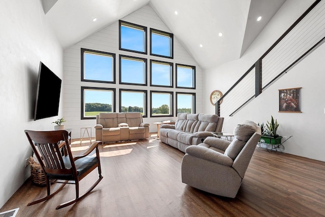 living area featuring visible vents, dark wood-type flooring, stairs, high vaulted ceiling, and recessed lighting