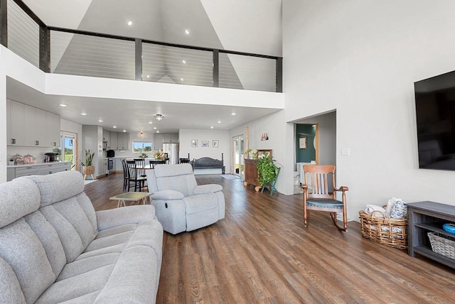 living room featuring a towering ceiling and wood finished floors