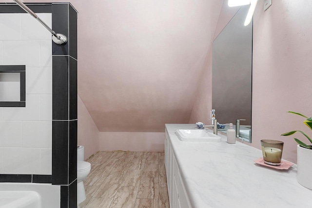 full bathroom featuring vaulted ceiling, vanity, and toilet