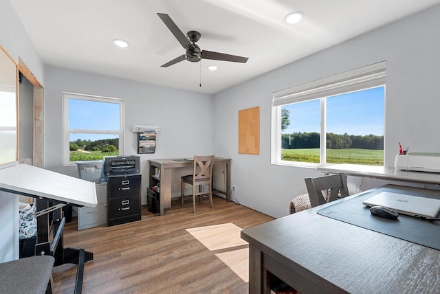 home office with a wealth of natural light, a ceiling fan, wood finished floors, and recessed lighting