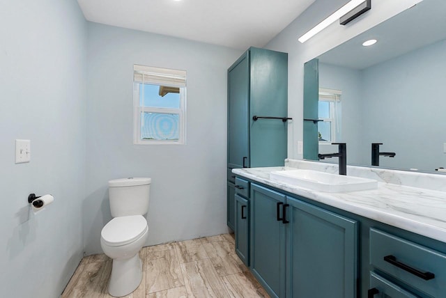 half bathroom featuring vanity, toilet, and wood finished floors