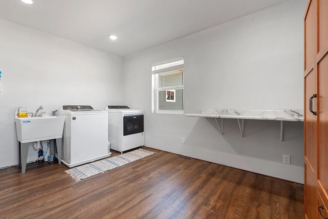 washroom with recessed lighting, a sink, separate washer and dryer, wood finished floors, and laundry area