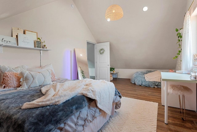 bedroom with vaulted ceiling and wood finished floors