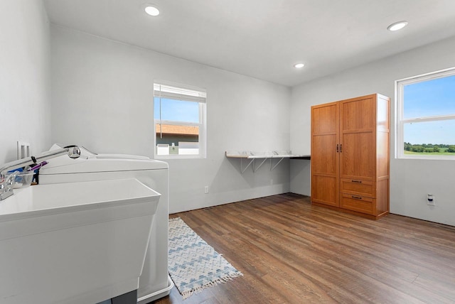 laundry area with laundry area, wood finished floors, a sink, and recessed lighting