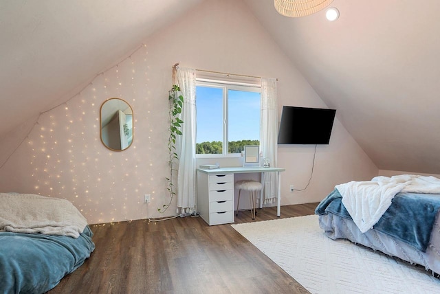 bedroom featuring lofted ceiling, wallpapered walls, and wood finished floors