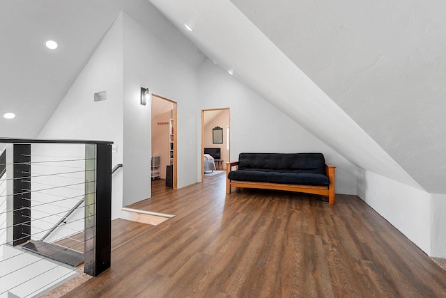 living area featuring vaulted ceiling, wood finished floors, an upstairs landing, and recessed lighting