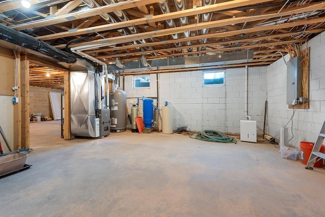 basement featuring heating unit, water heater, and electric panel