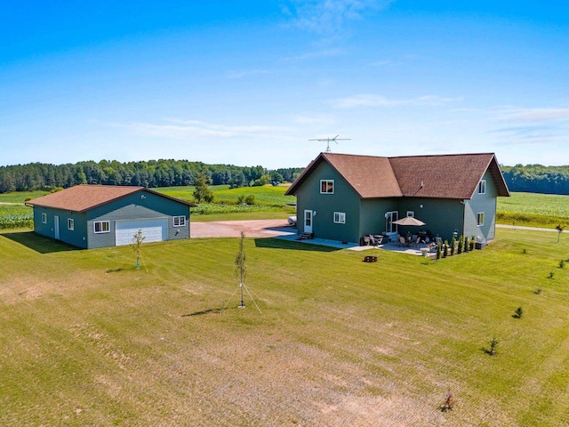 exterior space with a garage, a lawn, driveway, and an outdoor structure