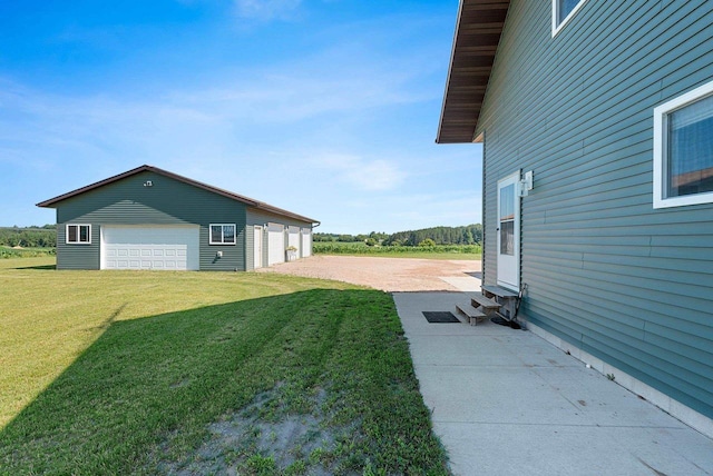 view of yard featuring entry steps, a detached garage, and an outdoor structure