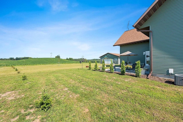 view of yard featuring a rural view, a patio area, and cooling unit