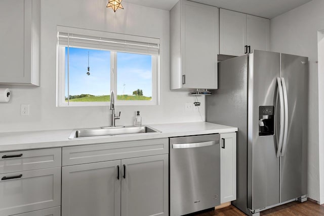 kitchen with dark wood-style floors, light countertops, appliances with stainless steel finishes, and a sink