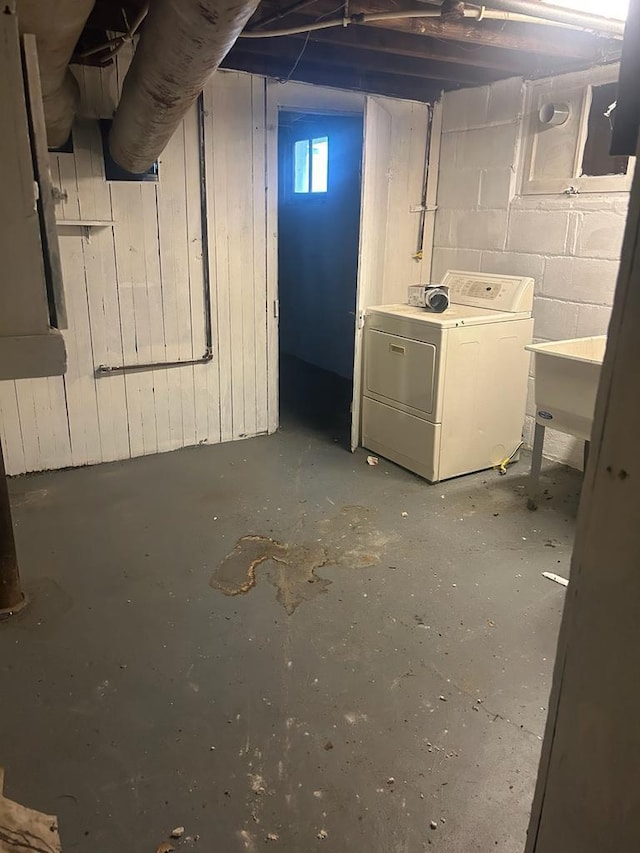 basement with concrete block wall, washer / clothes dryer, and a sink