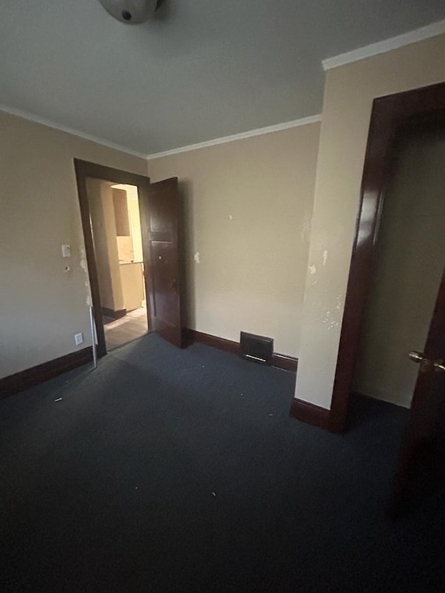 carpeted empty room featuring ornamental molding and baseboards