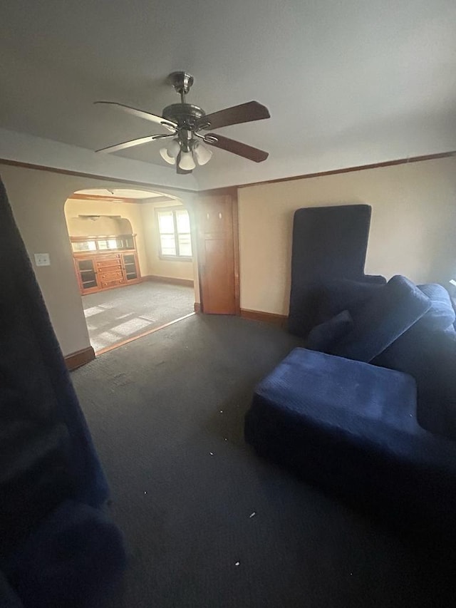 interior space featuring arched walkways, ceiling fan, carpet flooring, and baseboards