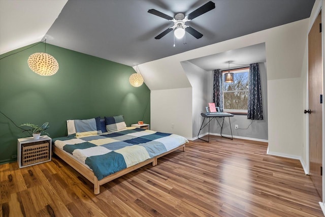 bedroom with lofted ceiling, wood finished floors, a ceiling fan, and baseboards