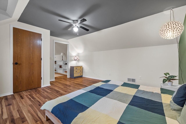 bedroom with lofted ceiling, wood finished floors, a ceiling fan, visible vents, and baseboards