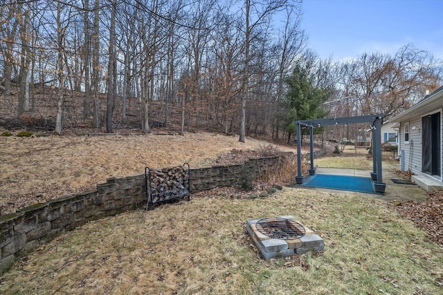 view of yard with a fire pit and a pergola