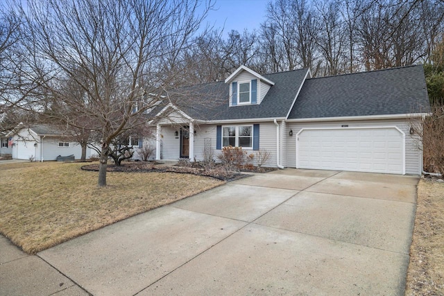 cape cod-style house with concrete driveway, roof with shingles, an attached garage, and a front yard