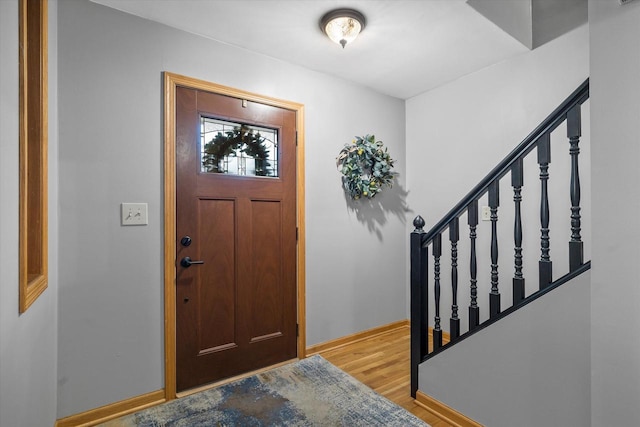 entrance foyer featuring light wood finished floors, stairway, and baseboards