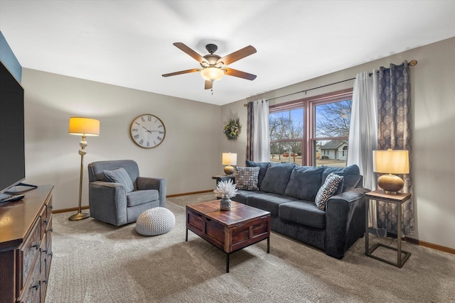 carpeted living room with baseboards and a ceiling fan