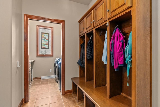 mudroom featuring light tile patterned flooring, baseboards, and separate washer and dryer