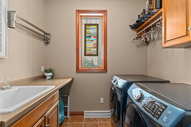 laundry room featuring washer and clothes dryer, cabinet space, a sink, tile patterned flooring, and baseboards