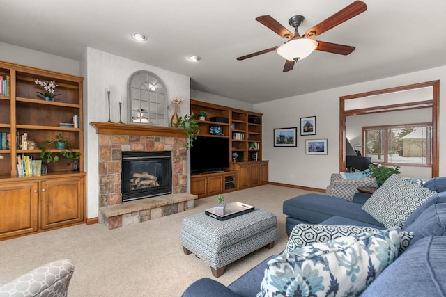 carpeted living area featuring recessed lighting, ceiling fan, a stone fireplace, and baseboards