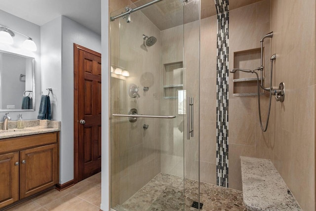 bathroom with a stall shower, tile patterned flooring, and vanity