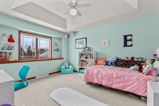 carpeted bedroom with baseboards, visible vents, a tray ceiling, and ceiling fan