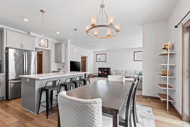 dining room featuring a chandelier, recessed lighting, and light wood-style floors