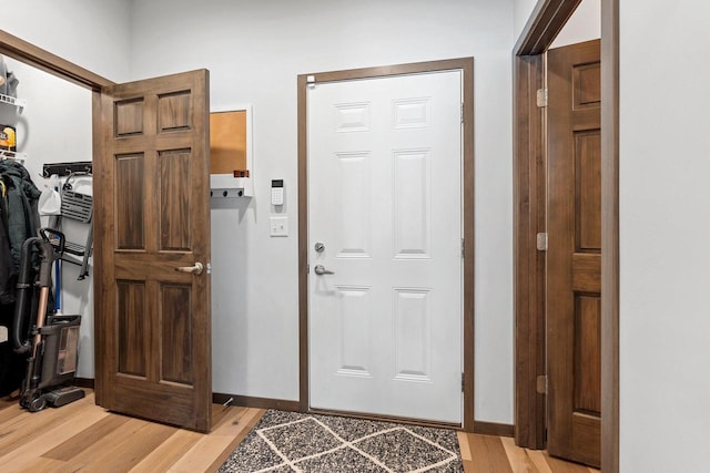 foyer entrance with light wood finished floors and baseboards