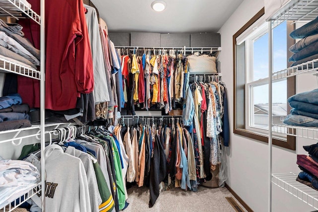 spacious closet featuring carpet, visible vents, and radiator heating unit