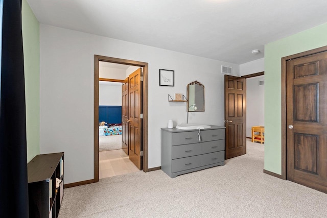 bedroom featuring baseboards, visible vents, and light colored carpet