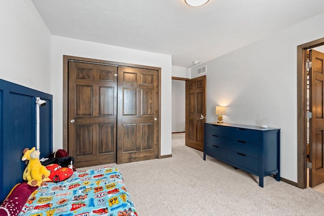 bedroom with light carpet, a closet, visible vents, and baseboards