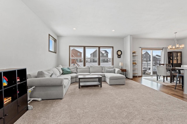 living room with a notable chandelier, wood finished floors, and recessed lighting