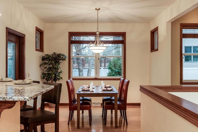 dining area featuring light wood-style flooring and baseboards