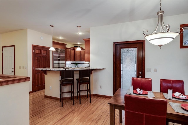 dining room with baseboards and light wood finished floors