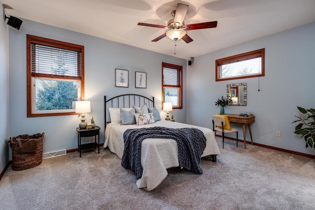 bedroom featuring carpet flooring, visible vents, and multiple windows