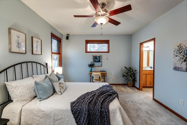 bedroom with light colored carpet, ceiling fan, ensuite bath, and baseboards